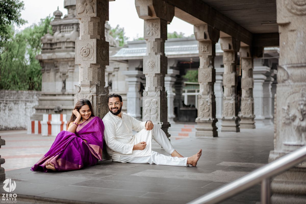 Traditional Indian architecture with ornate stone pillars and colonnade creates an elegant backdrop for a cultural photo shoot.