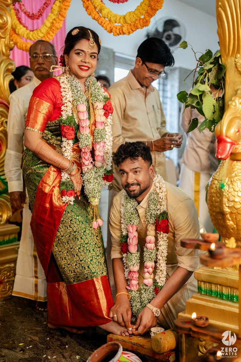 Couple in traditional South Indian wedding attire with floral garlands during a Hindu marriage ceremony.