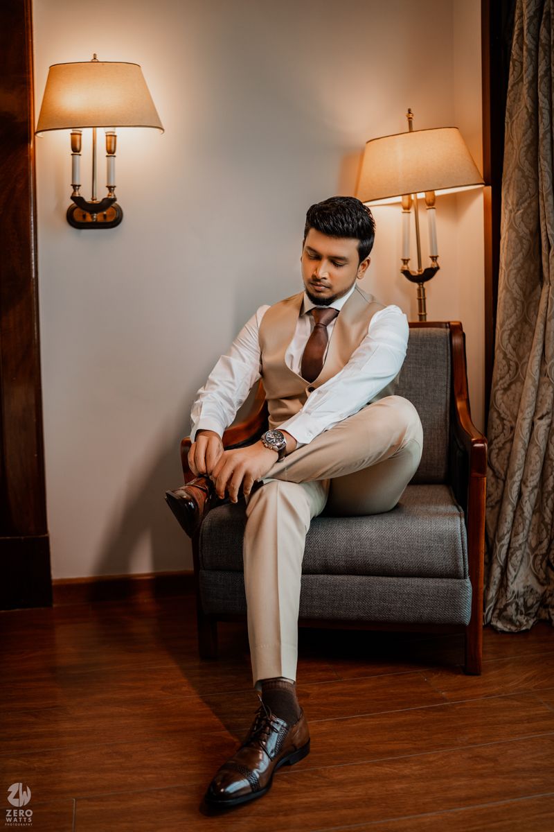 A series of elegant photos showing someone seated on a gray couch wearing a white suit and dress shoes in warm lighting.