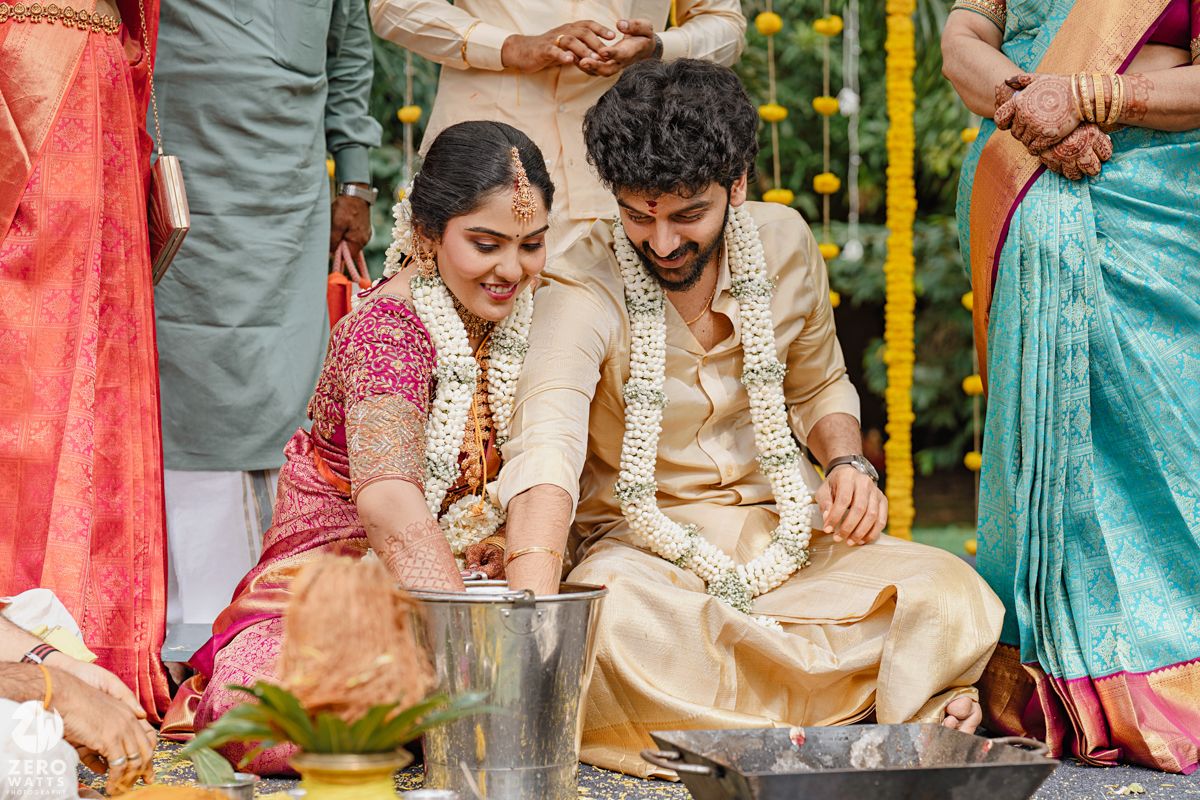 Wedding celebration with guests in traditional Indian attire under yellow floral decorations.