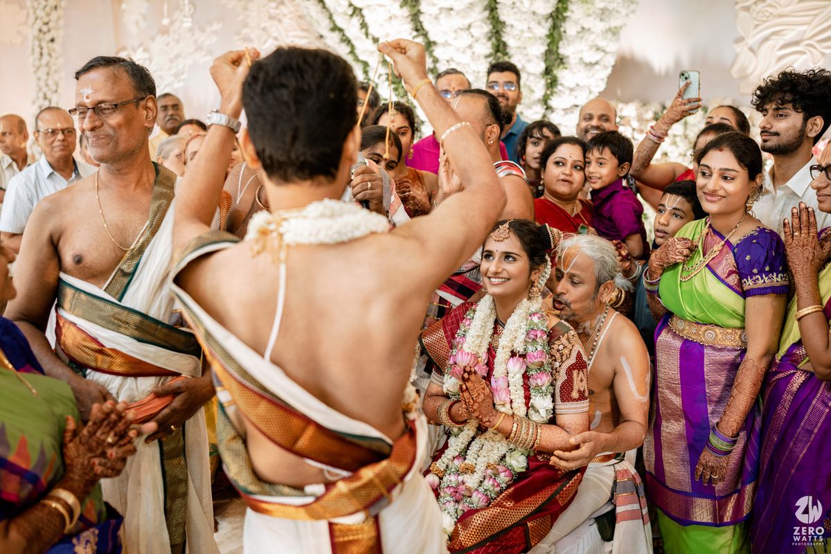 Joyous celebration at an Indian wedding with guests dancing and enjoying the festivities indoors.