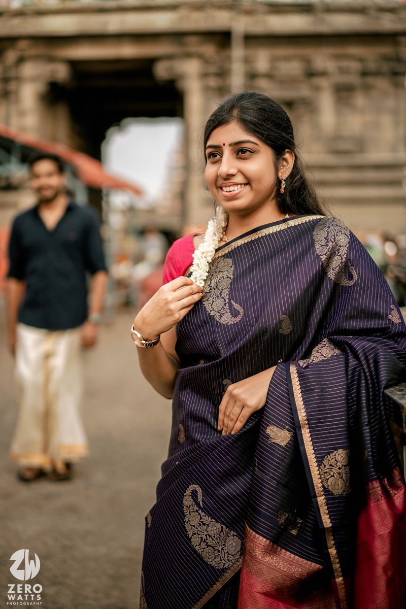 Candid expressions and poses photographed near ancient temple entrance with intricate stone carvings.