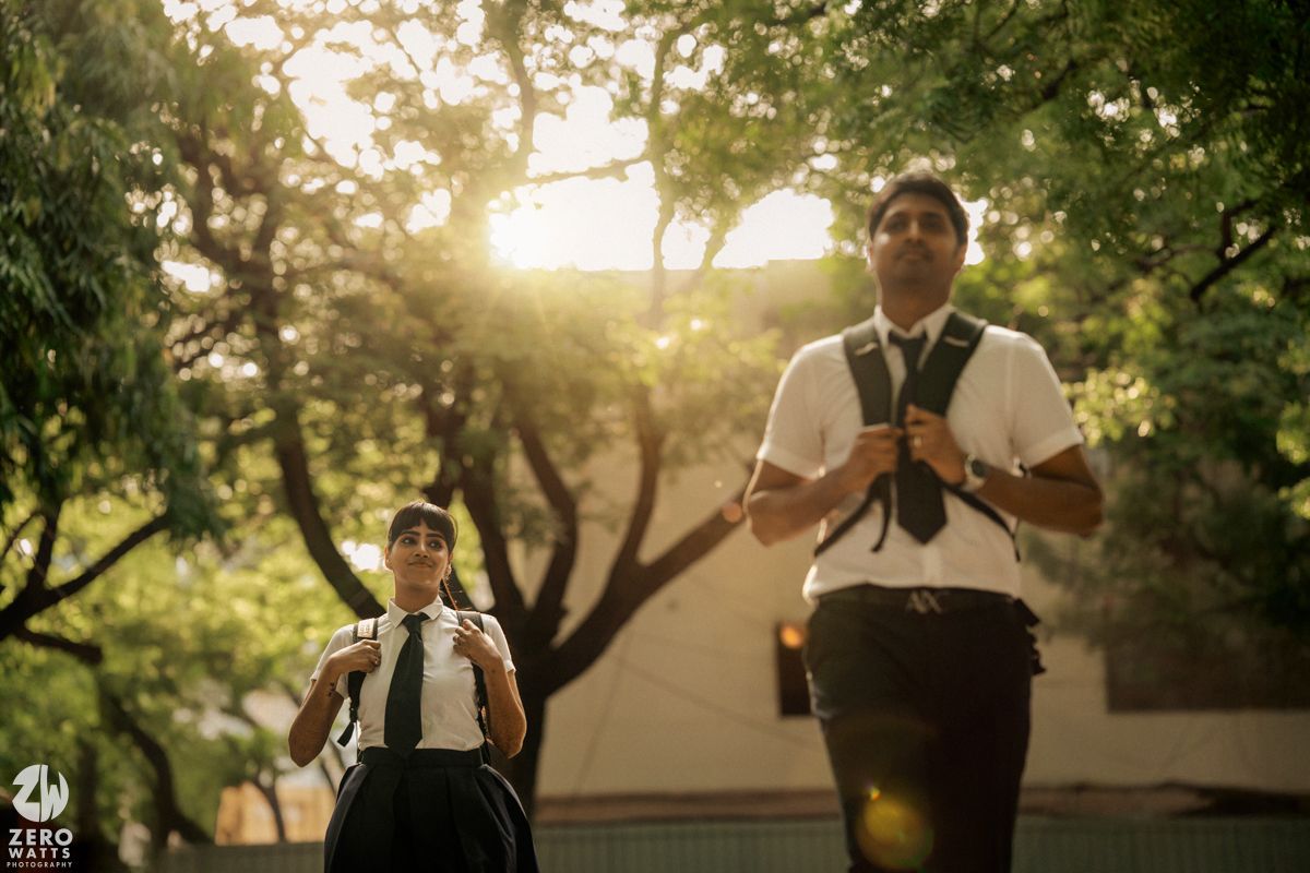 Students in uniforms stand in golden afternoon sunlight among trees.