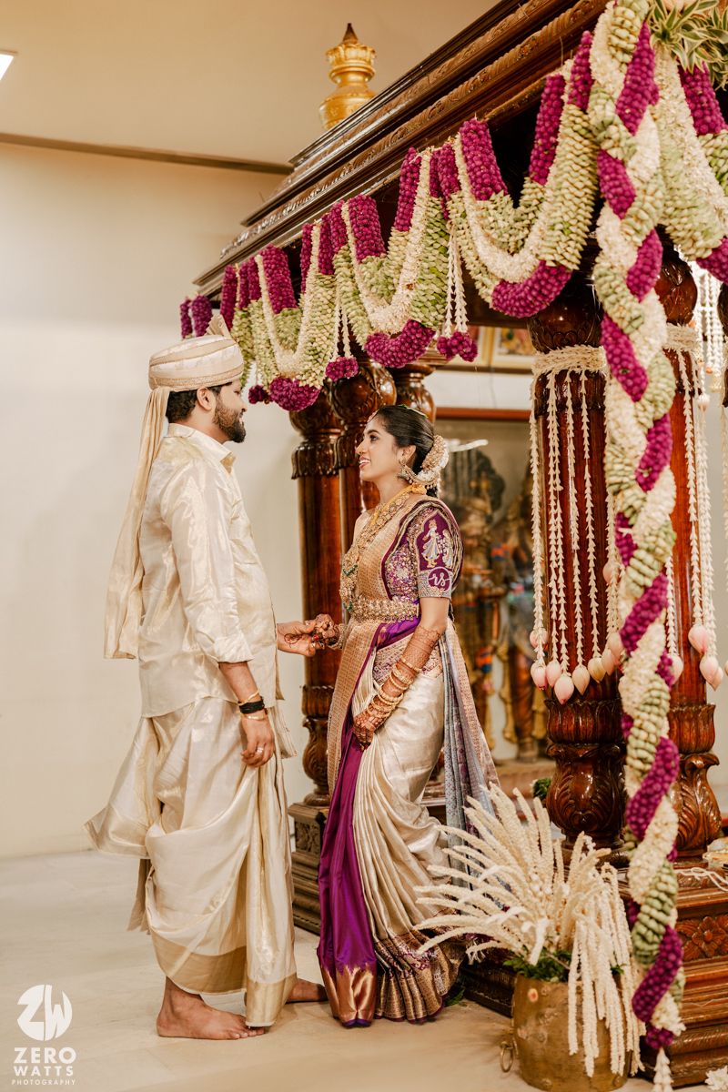 Traditional Indian wedding ceremony with colorful floral garlands and decorative elements in an indoor setting.