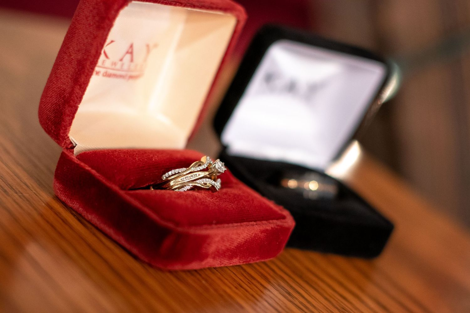 Diamond wedding ring displayed in red velvet jewelry box.
