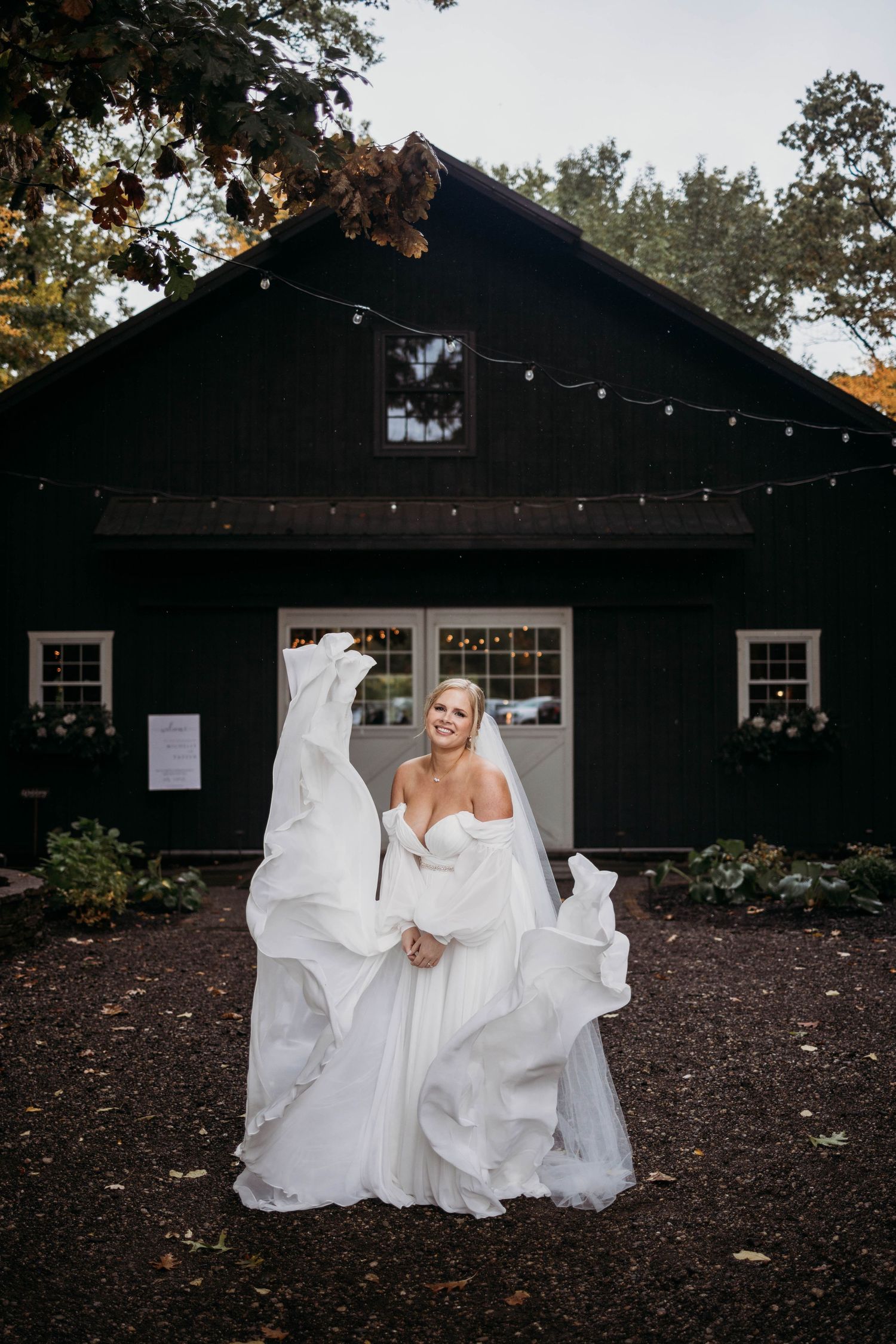 White wedding dresses contrast against a dark building exterior with string lights.