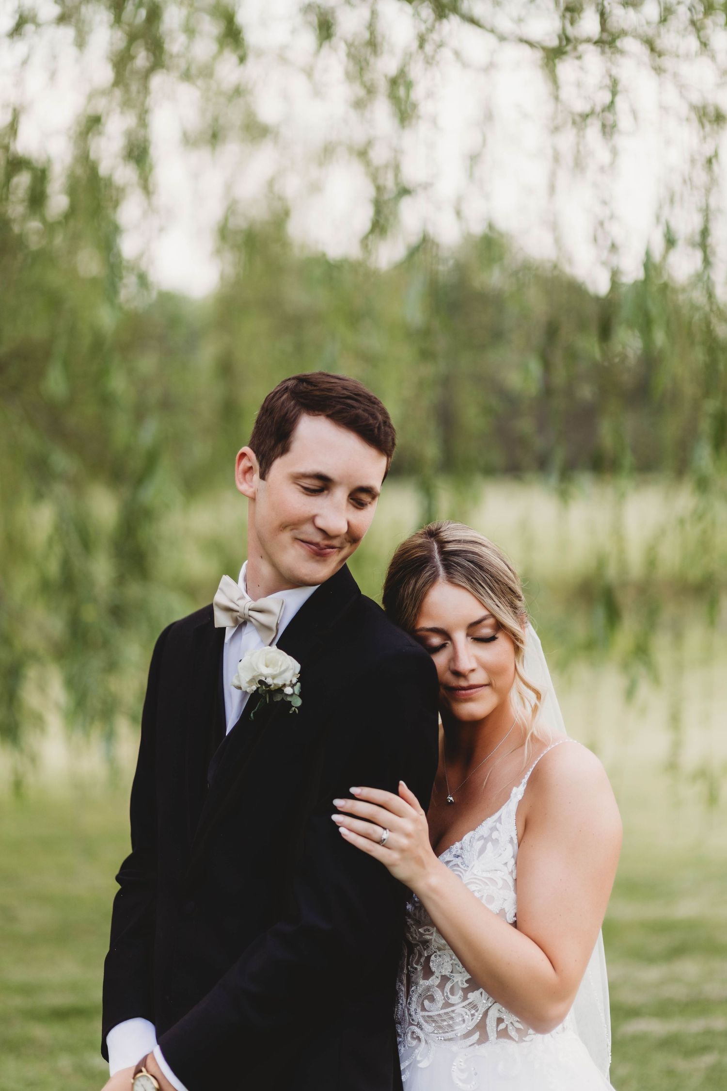 Romantic wedding portraits under willow trees showing tender moments between newlyweds.