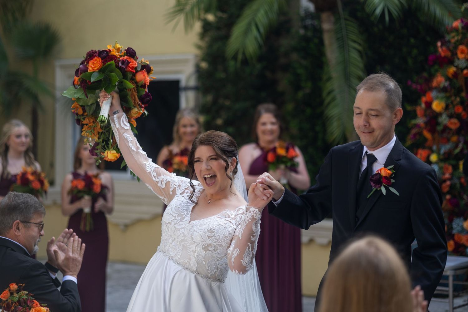Joyful celebration moment during outdoor wedding ceremony with autumn decorations.