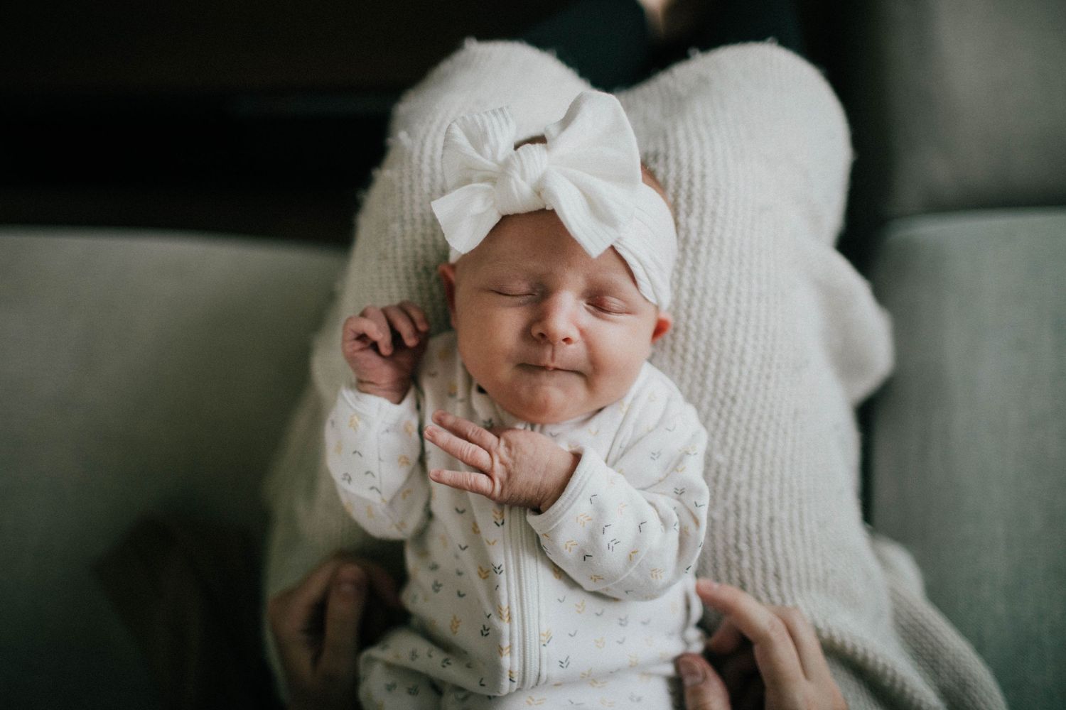 Image of newborn baby girl wearing a big white bow.