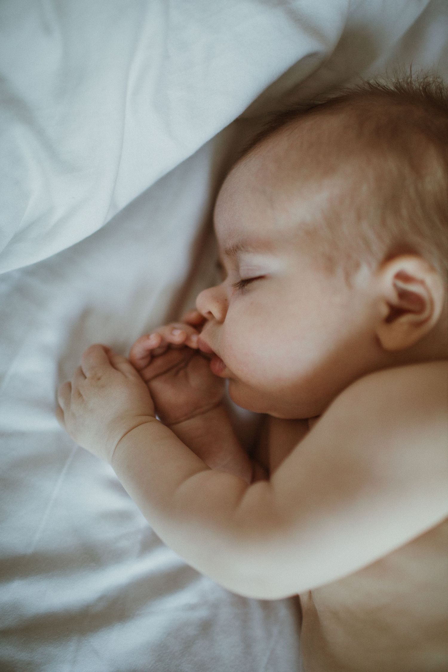 Image of newborn baby's profile while sleeping on his side.