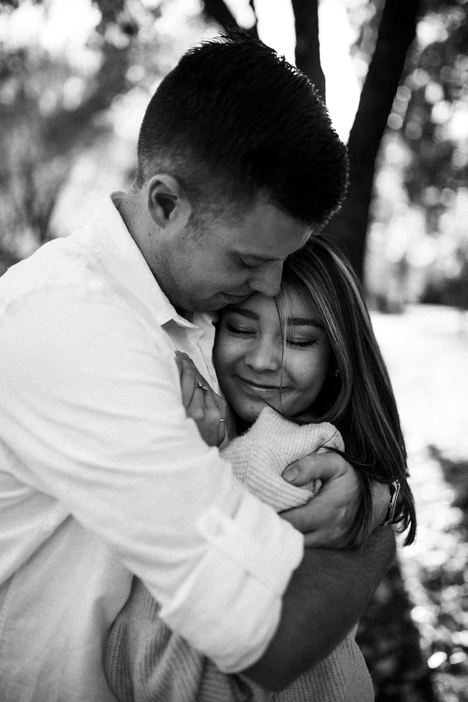 A romantic black and white photo series showing tender moments between a couple embracing in nature.