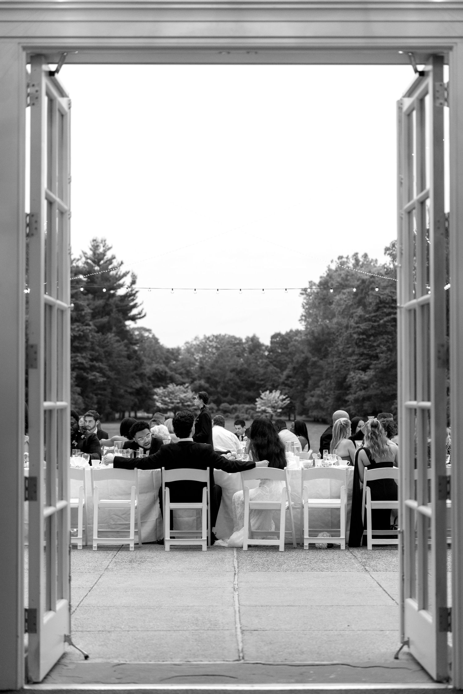 An outdoor wedding venue setup with white chairs and open-air frames.