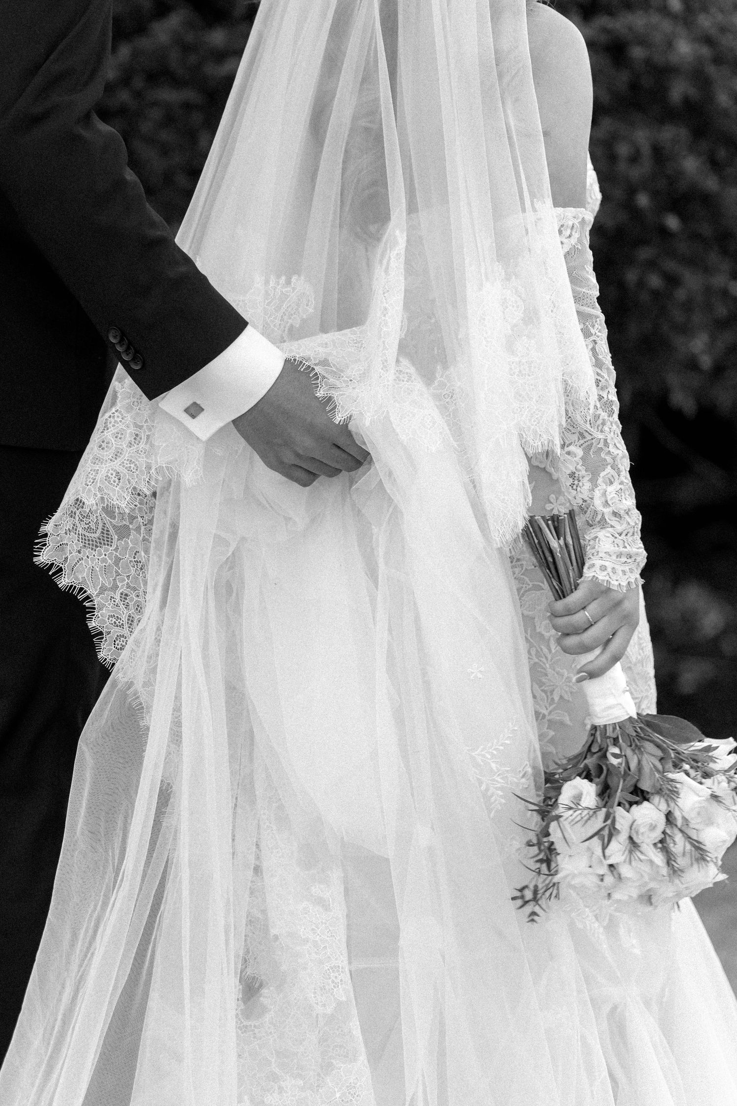 Black and white detail shots of a wedding dress train with delicate lace trim.