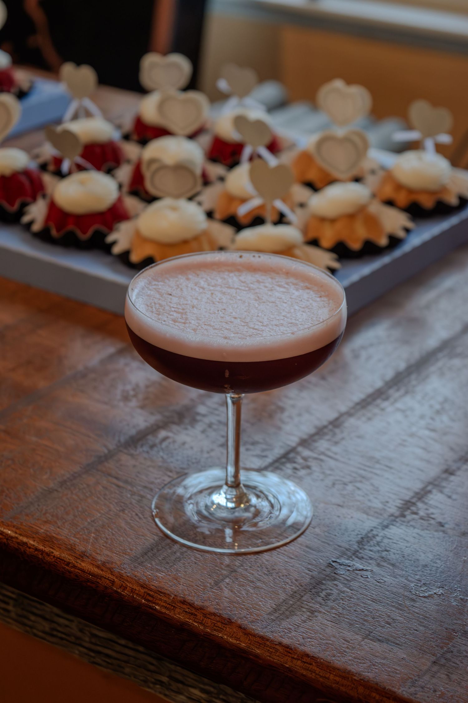 A chocolate cocktail with heart-shaped cookies on a rustic wooden surface creates an elegant presentation.