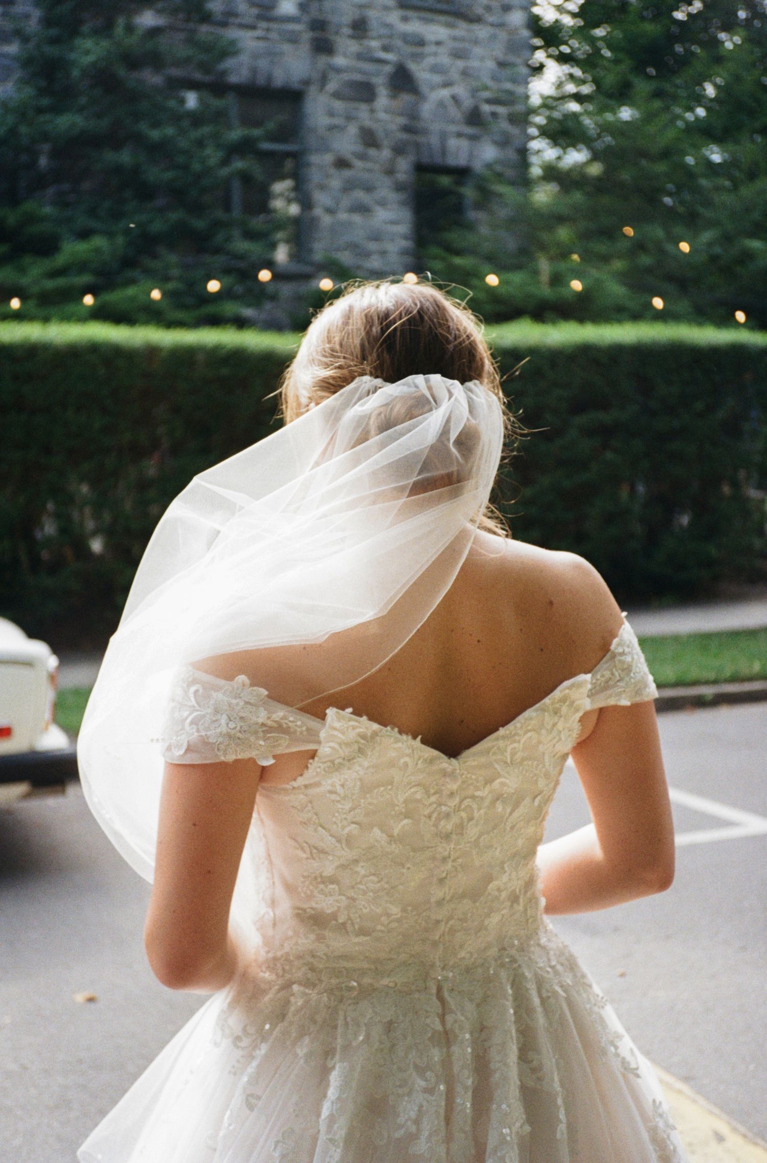 The back details of a white wedding dress with delicate lace trim and cap sleeves are shown in multiple angles.