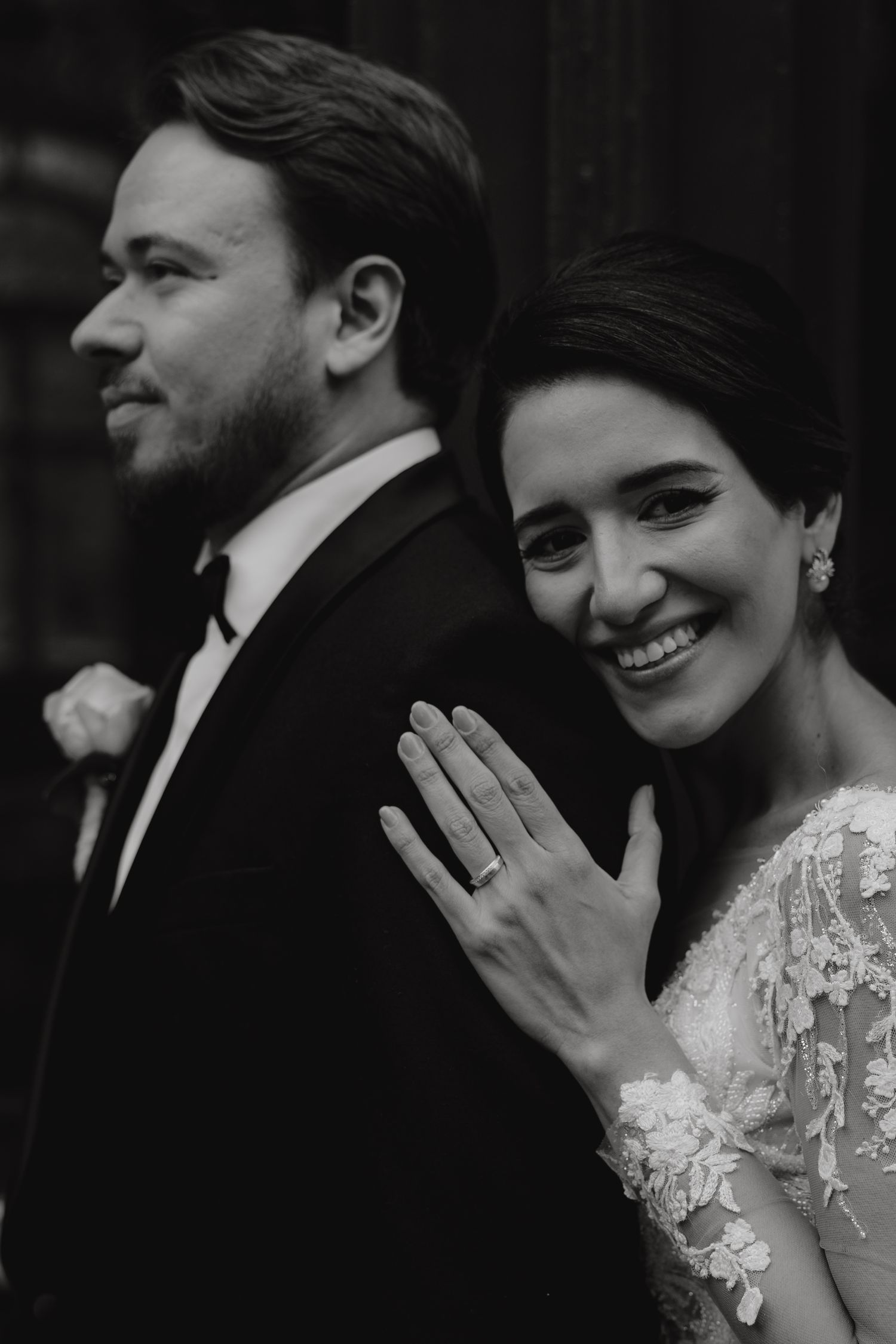 Black and white portrait of newlyweds showing off engagement ring.