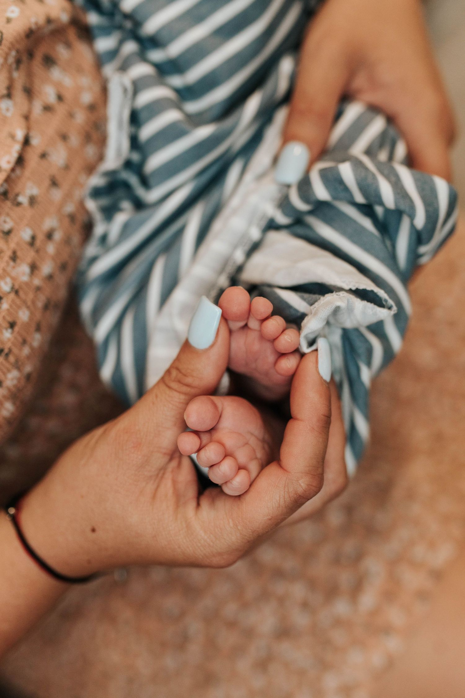 Close-up of a newborn holding a parent’s finger during an intimate lifestyle newborn photography session.