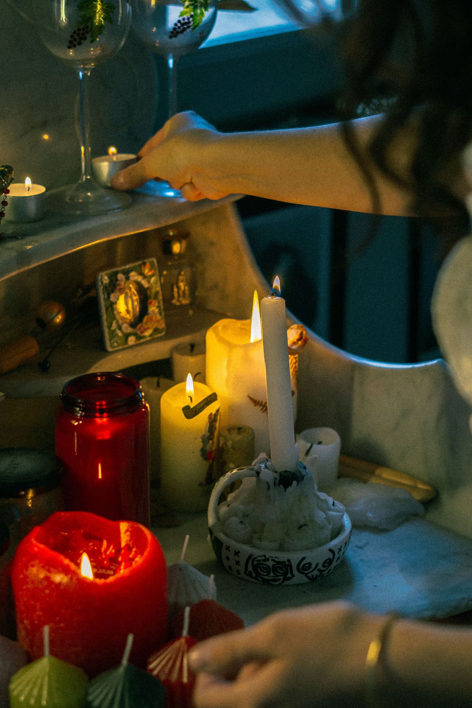 Photographie artistique de bougies allumées sur un autel dans un intérieur vintage, atmosphère spirituelle et poétique.