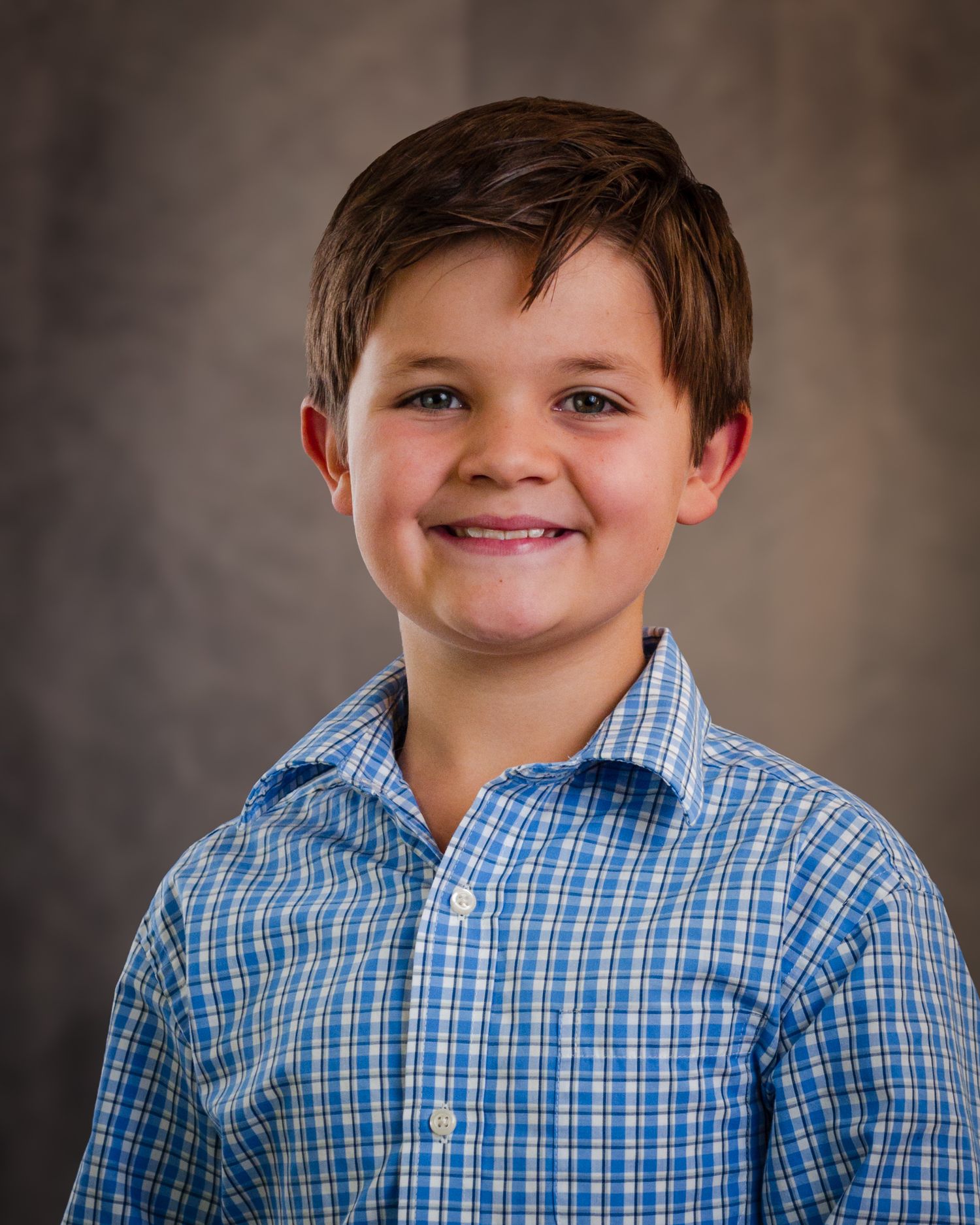 A series of four portrait photos showing a child in a blue checkered shirt against a dark background.