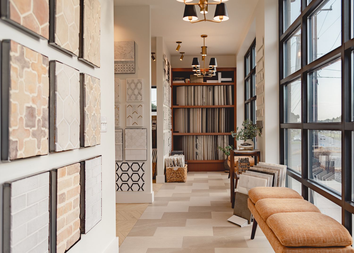 Modern interior hallway with tan leather seating and large windows showcasing an industrial-chic design aesthetic.
