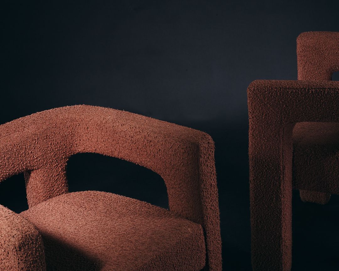 Abstract architectural shapes in terracotta brown color against a dark background create a minimalist composition.