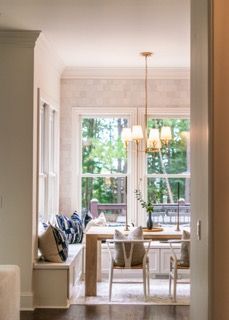 Modern open concept living room with white walls, large windows, and contemporary furnishings bathed in natural light.