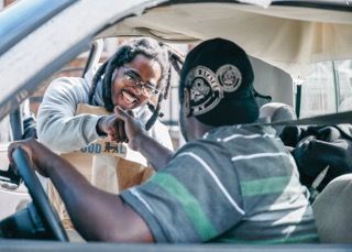 Two people having an animated conversation while sitting in a parked car.