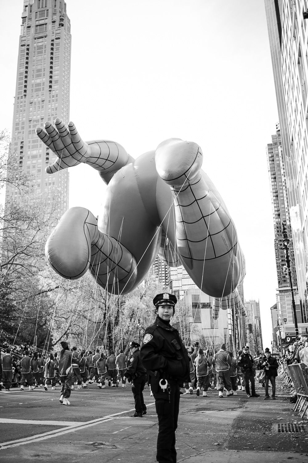 A large Spider-Man balloon floats above a New York City street during the Macy's Thanksgiving Day Parade.