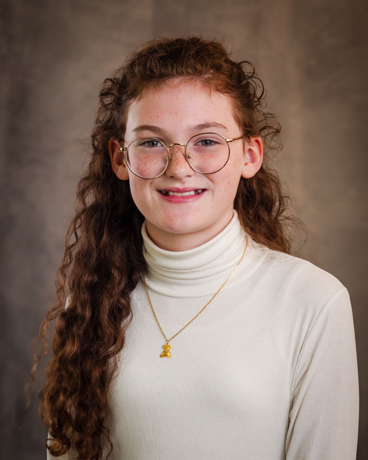 Portrait series showing different angles of a person with curly hair wearing a white turtleneck and gold necklace.