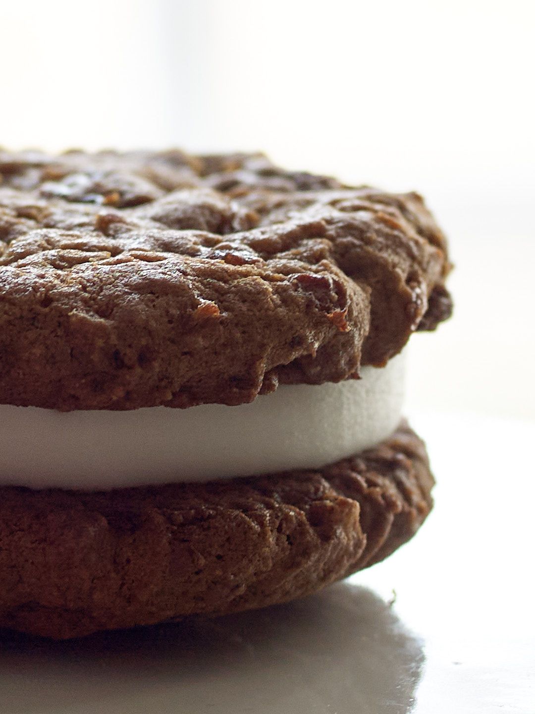 Chocolate sandwich cookies with creamy white filling stacked together in a close-up macro shot.