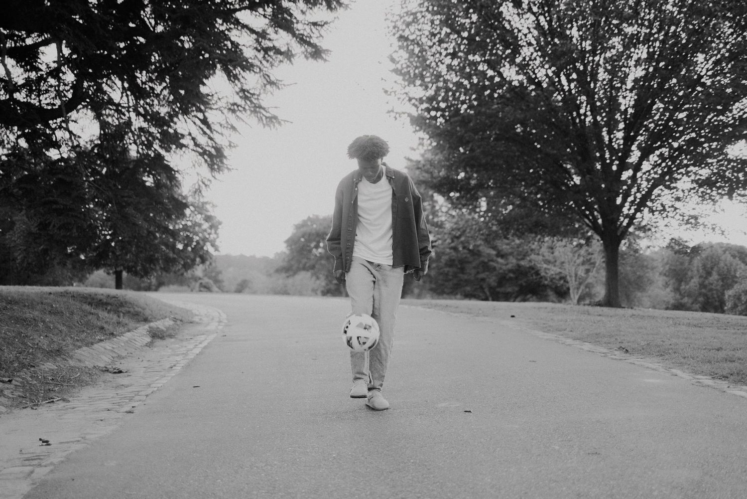 Black and white sequence showing someone walking along a tree-lined road, creating a cinematic progression.
