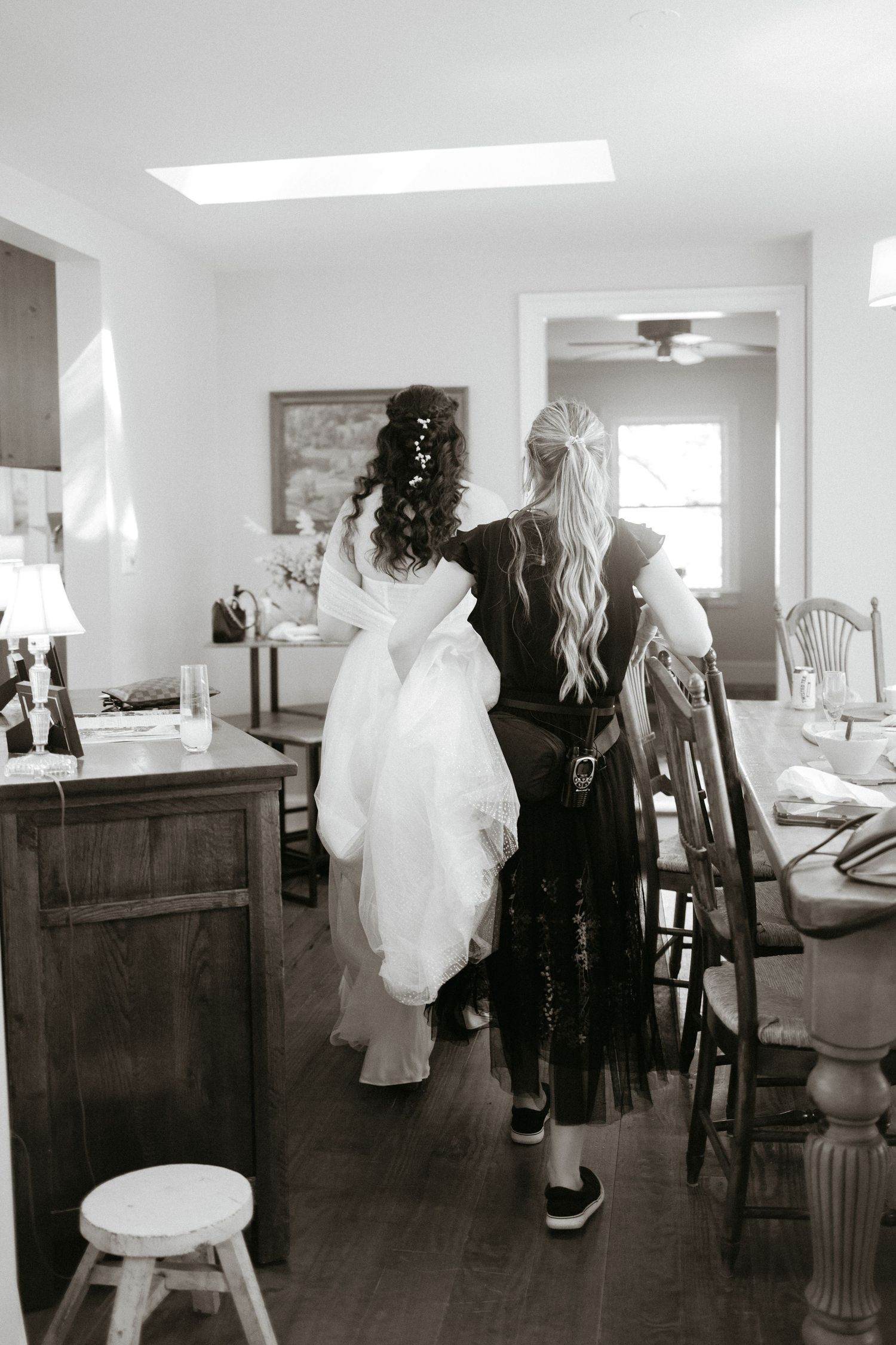 White ghost decorations and dark costumes are displayed in a rustic indoor setting for Halloween.
