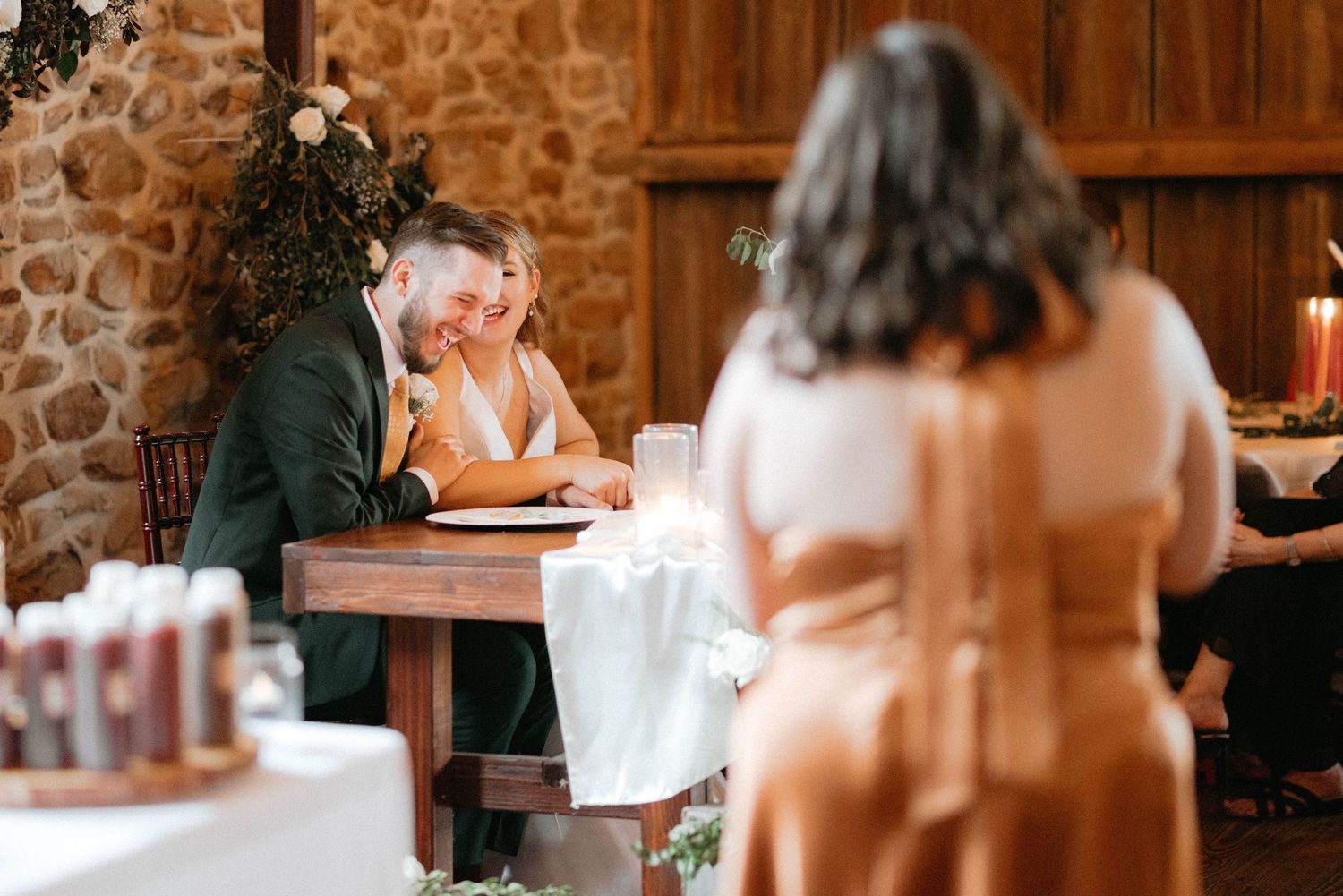 Wedding reception setup in a rustic venue with wooden tables and intimate lighting.