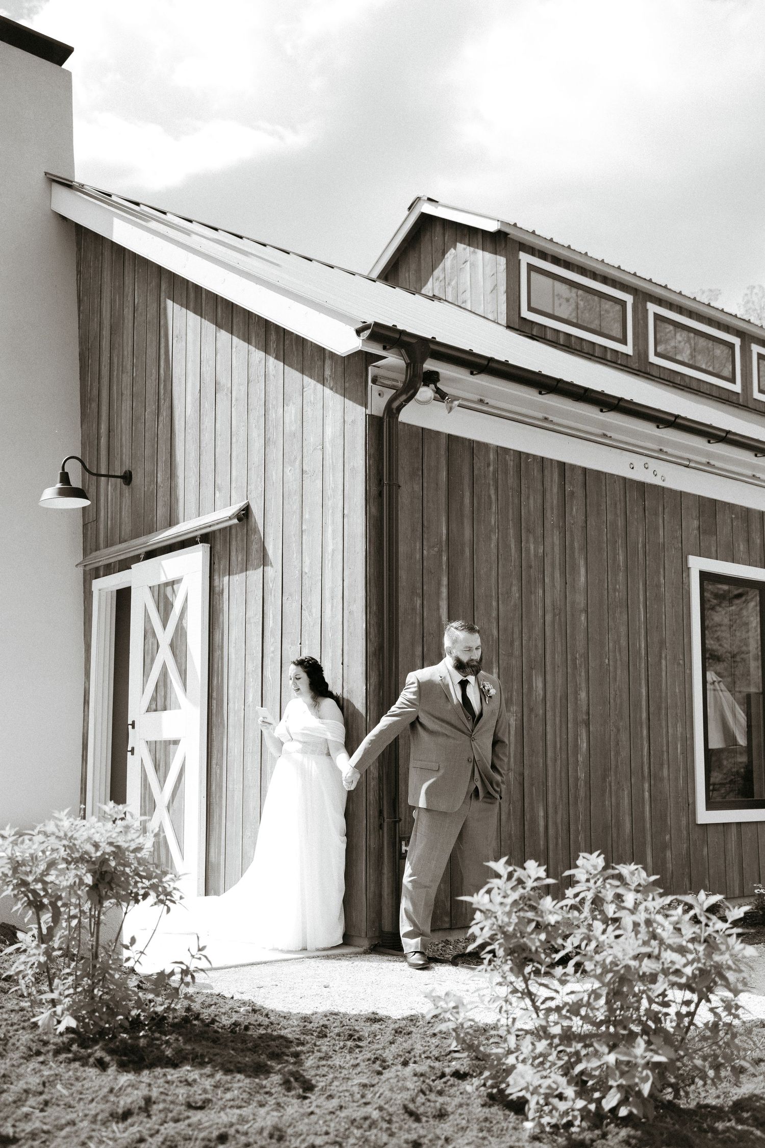 A playful first look sequence showing a rustic barn door with blooming bushes.