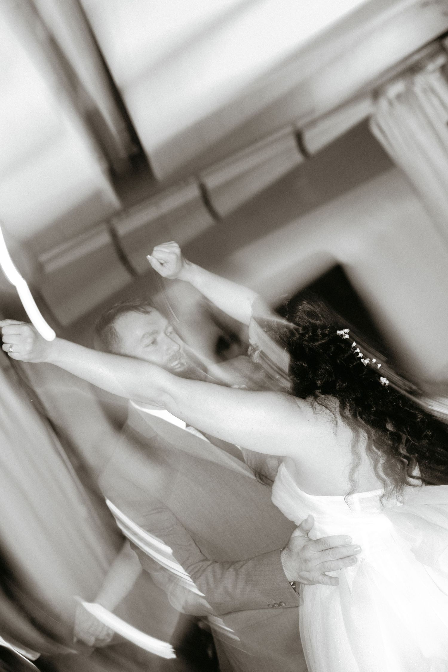 A couple dances gracefully in black and white, captured in an artistic motion blur.