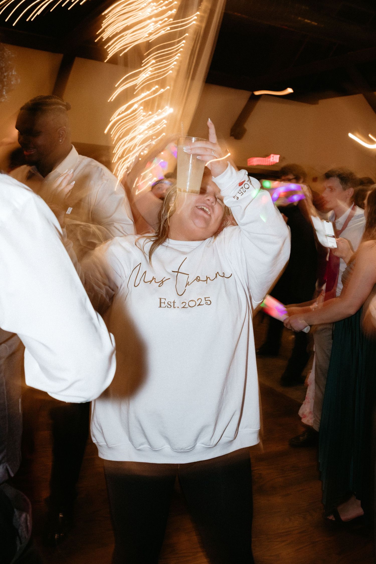 Dance party candid shots showing people moving and swaying on a dimly lit reception dance floor.