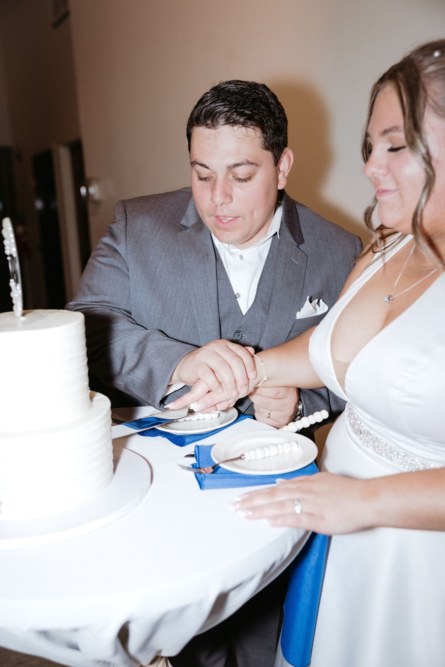 Wedding couple cutting their cake together at the reception with close-up detail shots.