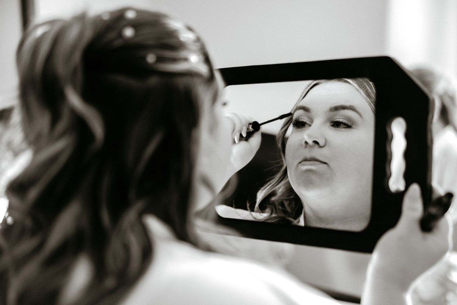Behind the scenes preparation of bridal makeup with brushes and mirror reflections.