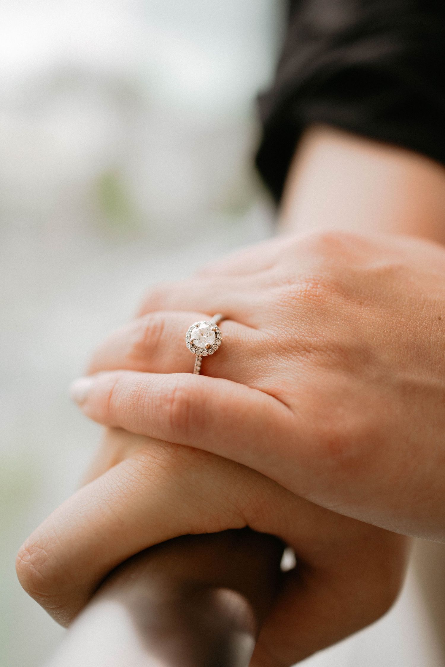 Close-up shots of a sparkling diamond solitaire engagement ring on someone's hand.