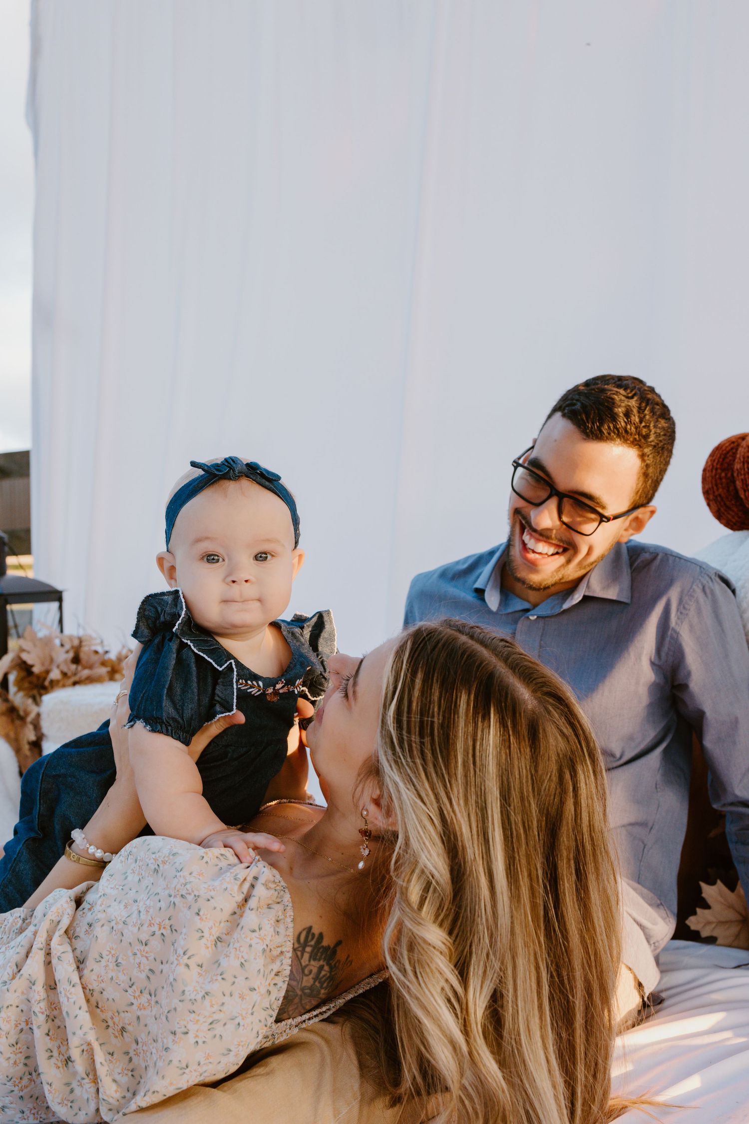 A collection of candid family moments captured in a bright, natural light setting against a white wall background.