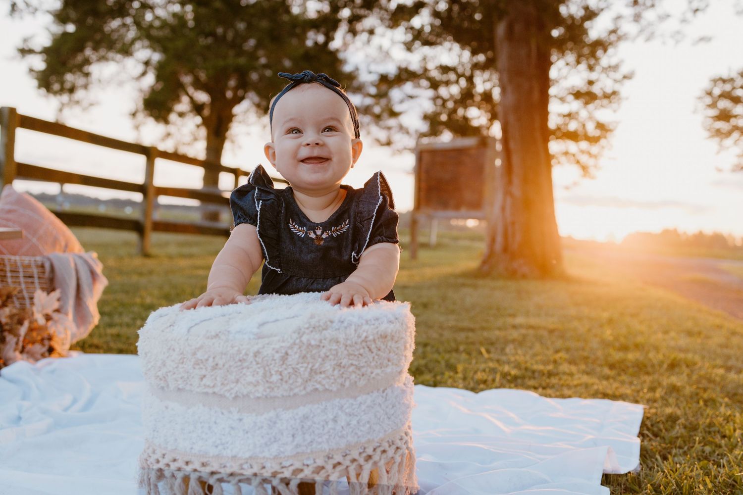 Child unwraps bubble wrap outside during golden sunset in grassy field.