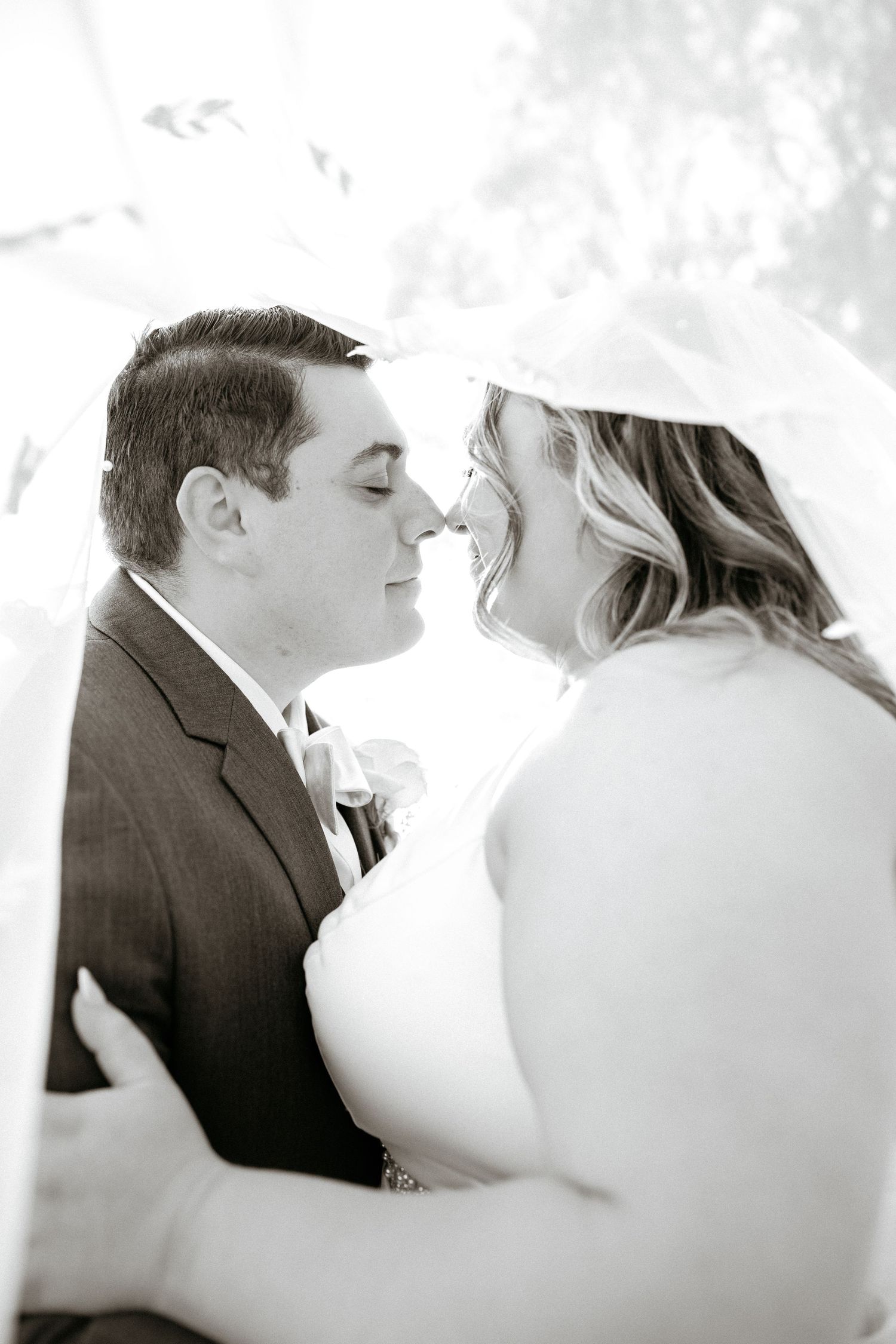 Black and white romantic portrait captured during an intimate wedding moment.