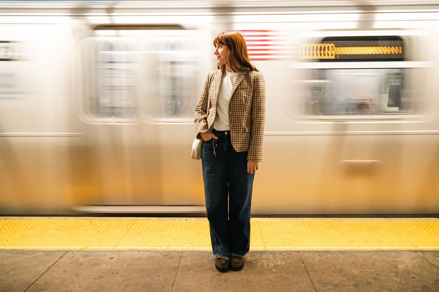 Motion blur of subway platform with yellow safety line visible.