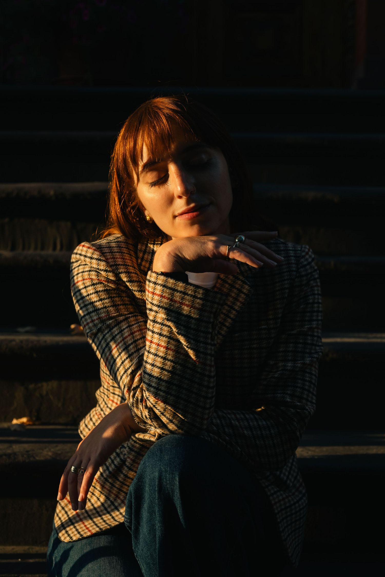 Moody low-light portraits in plaid clothing against dark background.