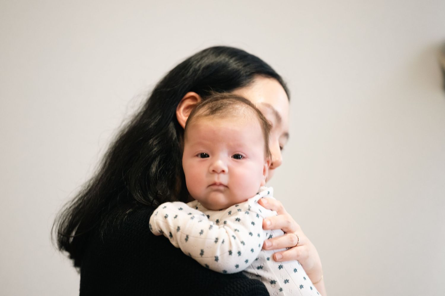 Sweet family portrait showing parents bonding with their baby in a minimalist home setting.