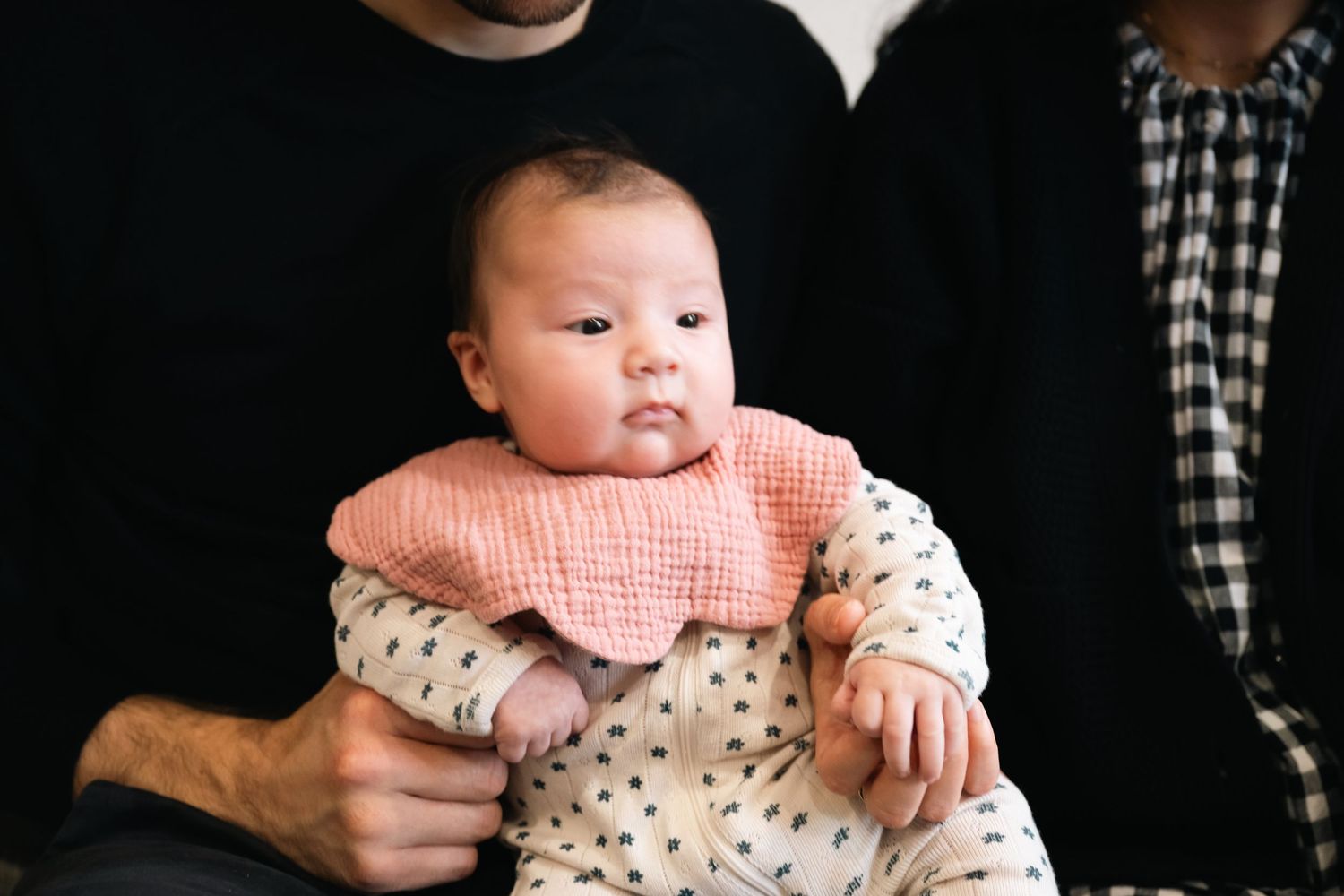 A baby wearing a polka dot onesie is held while making various facial expressions in a photo collage.