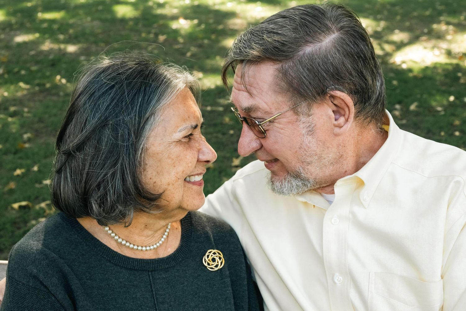Candid outdoor portraits showing tender moments between an elderly couple.