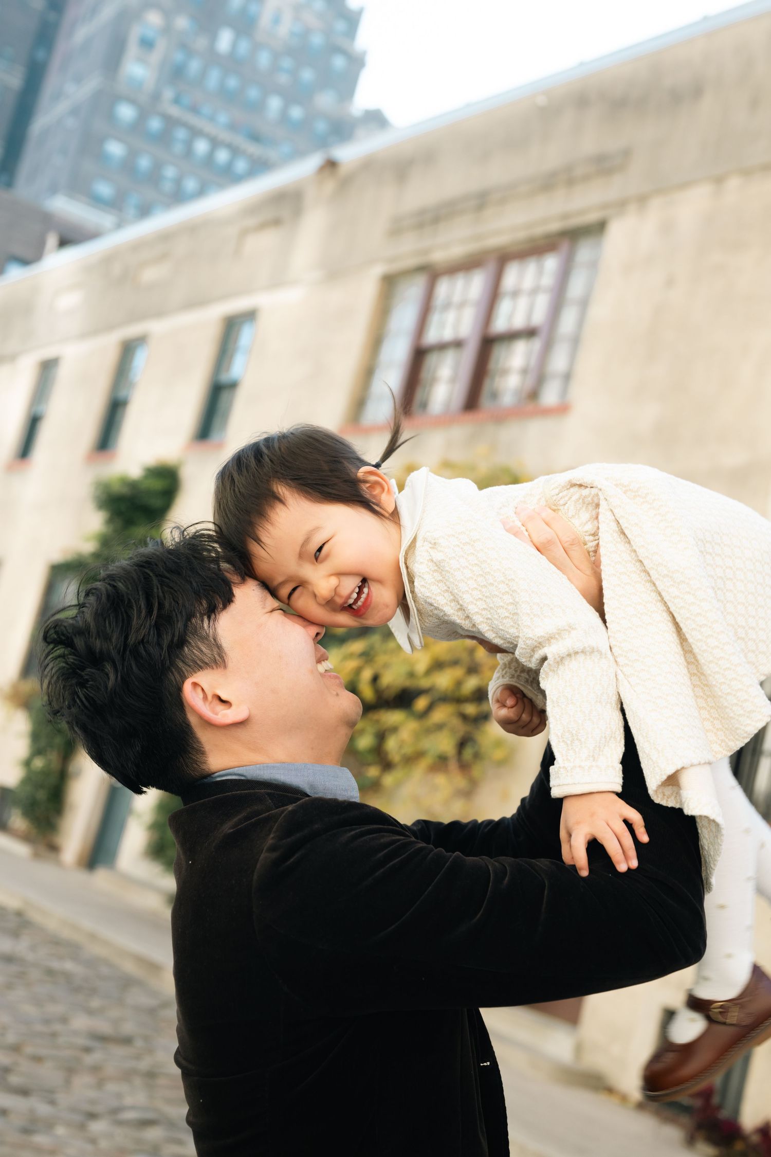 Joyful interactions captured against an urban backdrop with tall buildings in the distance.