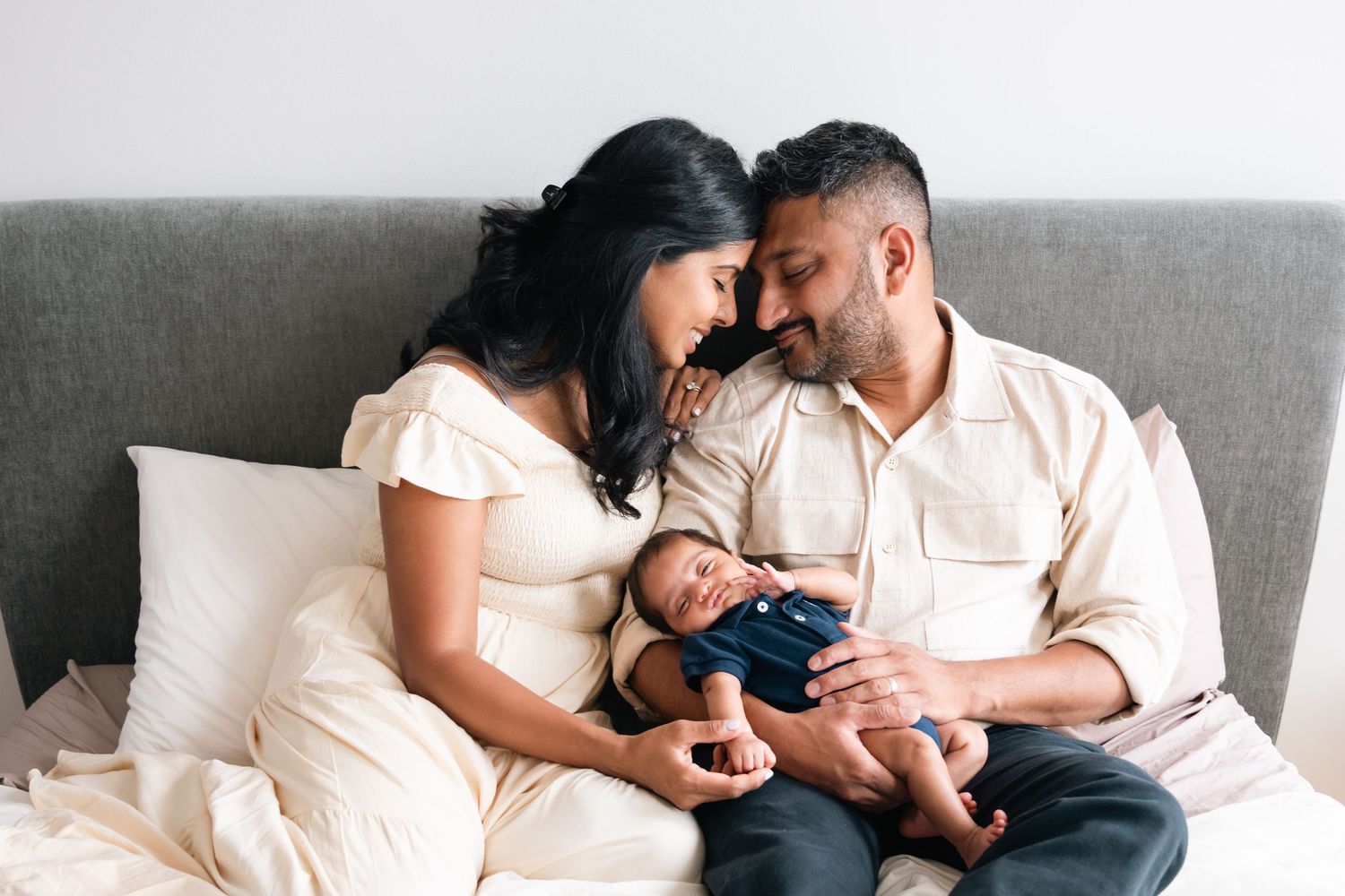 Family cuddles together on a couch during an intimate lifestyle photography session.