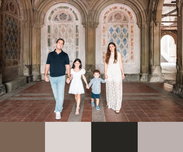 Family walking through an ornate stone archway with decorative architectural details and columns.